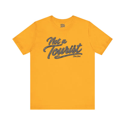Knox Nixon NOT A TOURIST Dark script graphic T-shirt in gold yellow